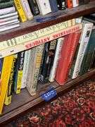 Book contents of three shelves: history, short stories, National Geographics, misc