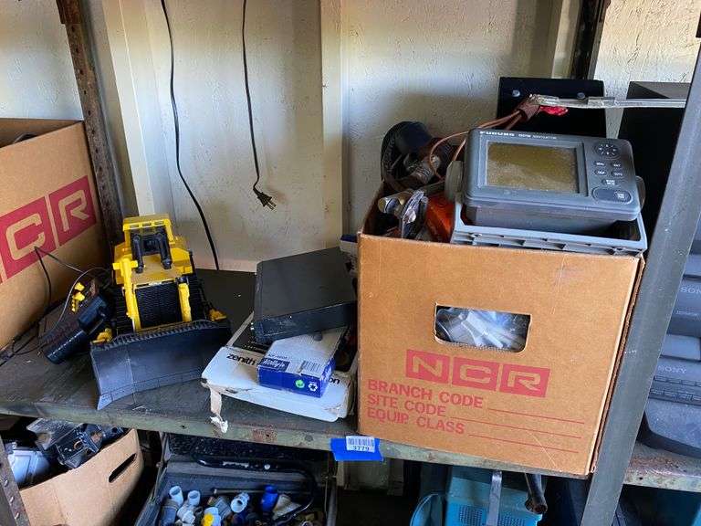 Contents of shelf: CAT wired remote control bulldozer, Realistic audio power meter, electronics, spinning wheel parts, misc