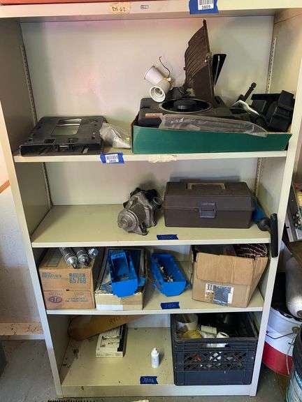 Contents of four shelves: case of STP 4-cylinder oil treatment, tackle box, gang boxes, switch plates, misc