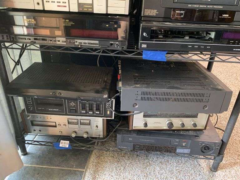 Contents of shelf: 8-track players, Toshiba satellite receiver, Pioneer amplifier, Mitsubishi VCR