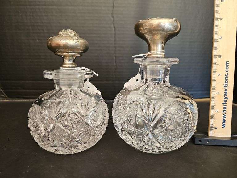 Two cut glass perfume bottles w/ repousse Sterling stoppers