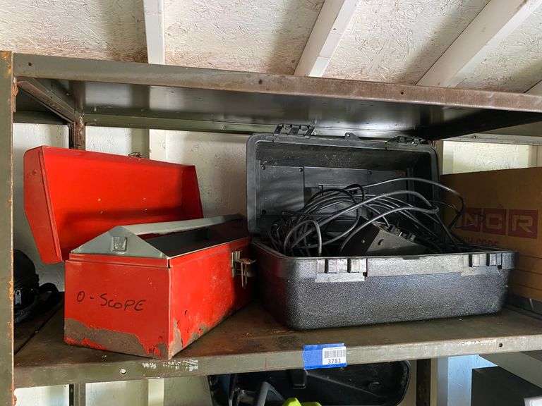 Contents of shelf: red metal toolbox, misc