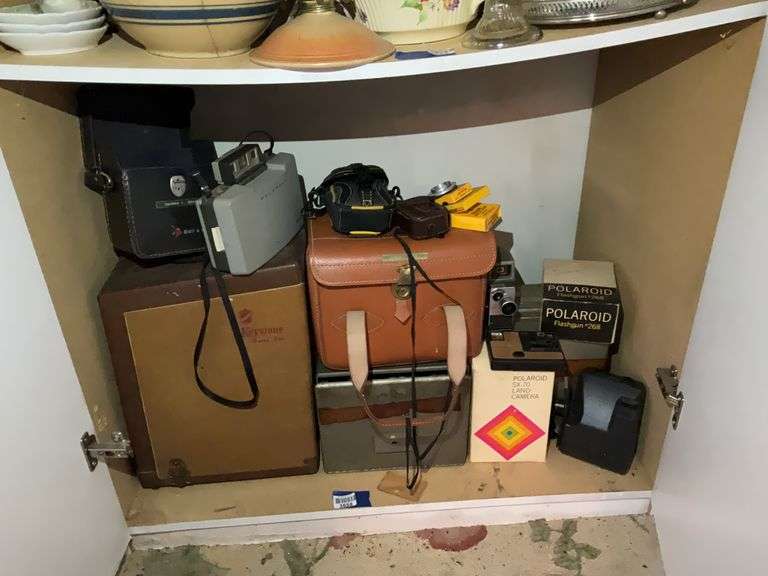 Contents of shelf: vintage camera lot including Polaroid, Canon, Keystone film projector