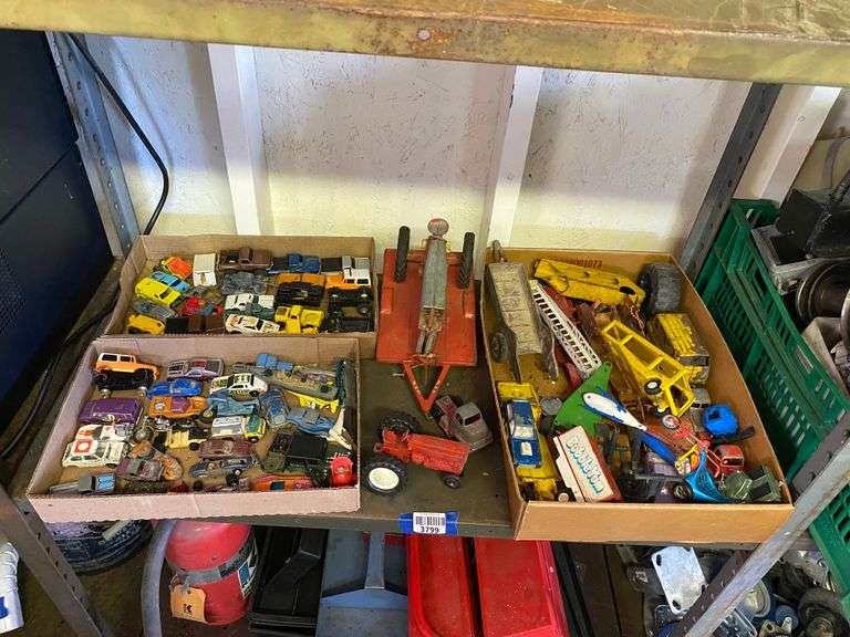 Contents of shelf: farm toy tractors and trailer, toy cars and trucks lot