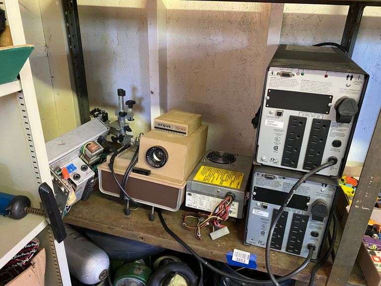 Contents of shelf: Argus slide projector, back up power supplies, misc