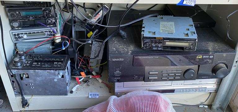 Contents of shelf: stereo receiver, VCR, car CD players