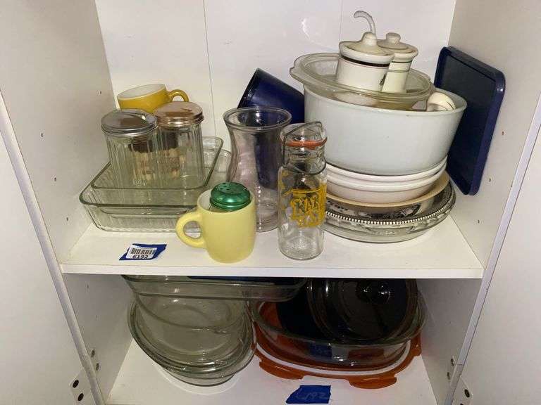 Contents of two shelves: glass bakeware, mixing bowl, misc kitchenware