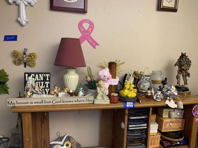 Contents of two shelves: lamp, figurines, decor items, CDs, Avon products, tic-tac-toe game