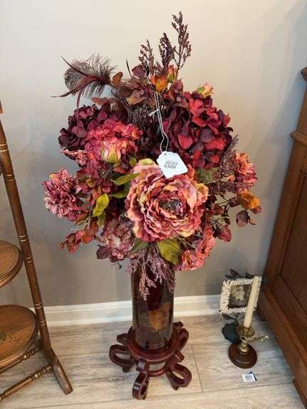 Faux floral arrangement in vase on wooden base
