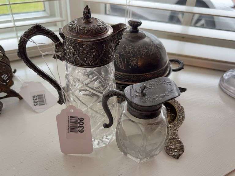 Glass syrup pitcher and decanter with metal tops, tea strainer, and Victorian butter dish with china drainer plate