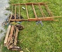Clothes rack, old lawn mower, rope, buckets of oil