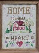 (Q) Framed Counted Crosstitch Piece Featuring Saying "Home Is Where The Heart Is"