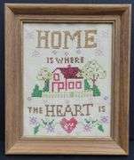 (Q) Framed Counted Crosstitch Piece Featuring Saying "Home Is Where The Heart Is"