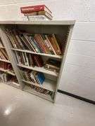 Metal shelving unit with assorted books.