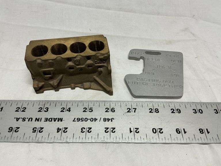 John Deere cast weight and GM brass engine block - Legacy Auction Company
