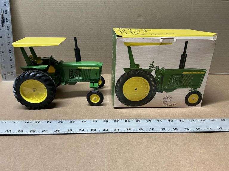 Vintage John Deere toy tractor with yellow canopy