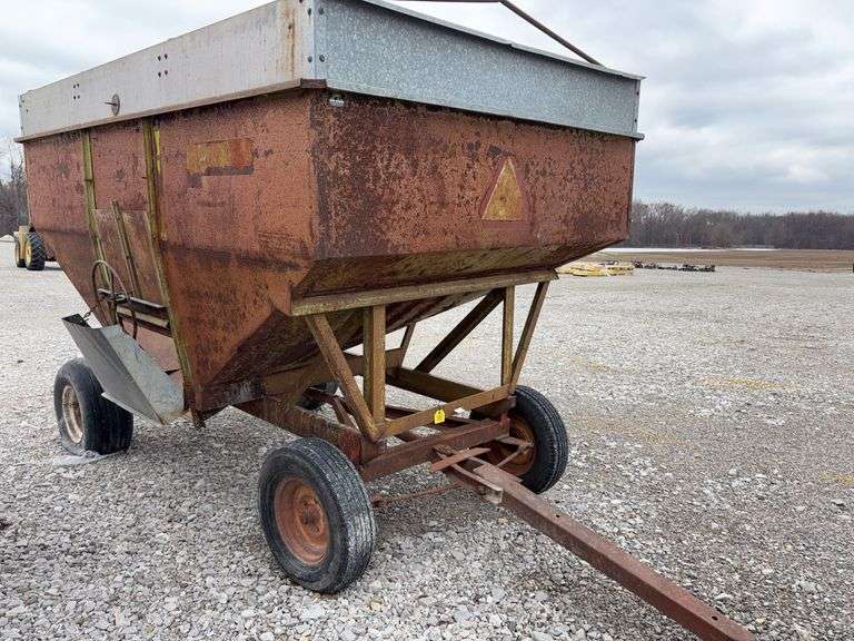 250 Bushel Gravity  Wagon, Tarp Bows,  Rear Tire Has Slow Leak, 3 tires hold Air, Inside and Outside of Bed is Rusty, Some Holes on Inside of Bed, Grain Chute Door does Operate, Towed in at 50MPH via Consignor