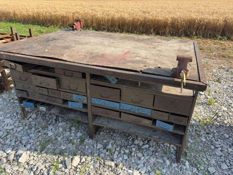 Workbench w/ (2) vises mounted to workbench, Vises are 3 1/2’’, Workbench size is 52” wide x 73” long x 36” high, Metal Frame w/ steel drawers with dividers in them, drawers on both sides of workbench bench, Masonite top over 2x lumber,