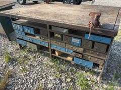 Workbench w/ (2) vises mounted to workbench, Vises are 3 1/2’’, Workbench size is 52” wide x 73” long x 36” high, Metal Frame w/ steel drawers with dividers in them, drawers on both sides of workbench bench, Masonite top over 2x lumber,