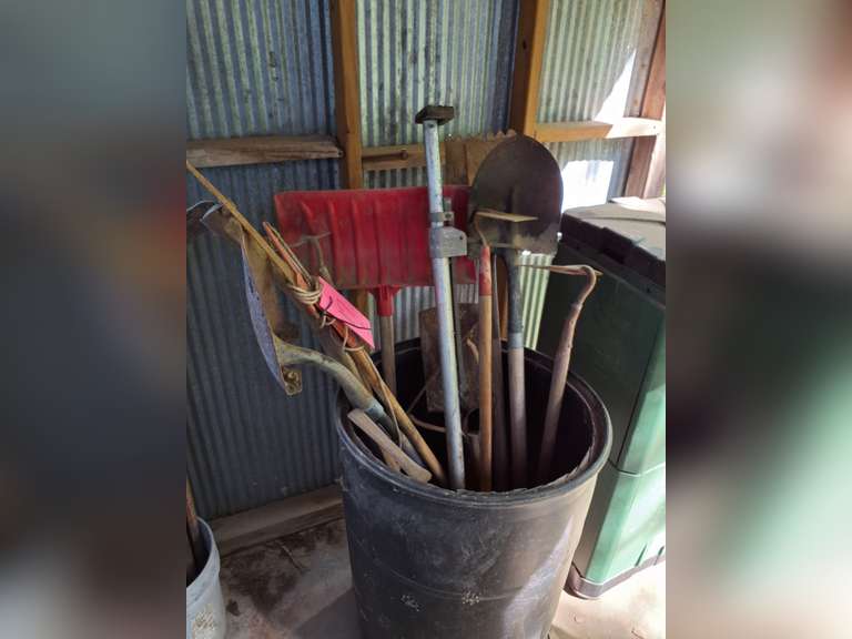 Barrel of garden tools: shovels, hoes, scythe, & metal can w/ lid