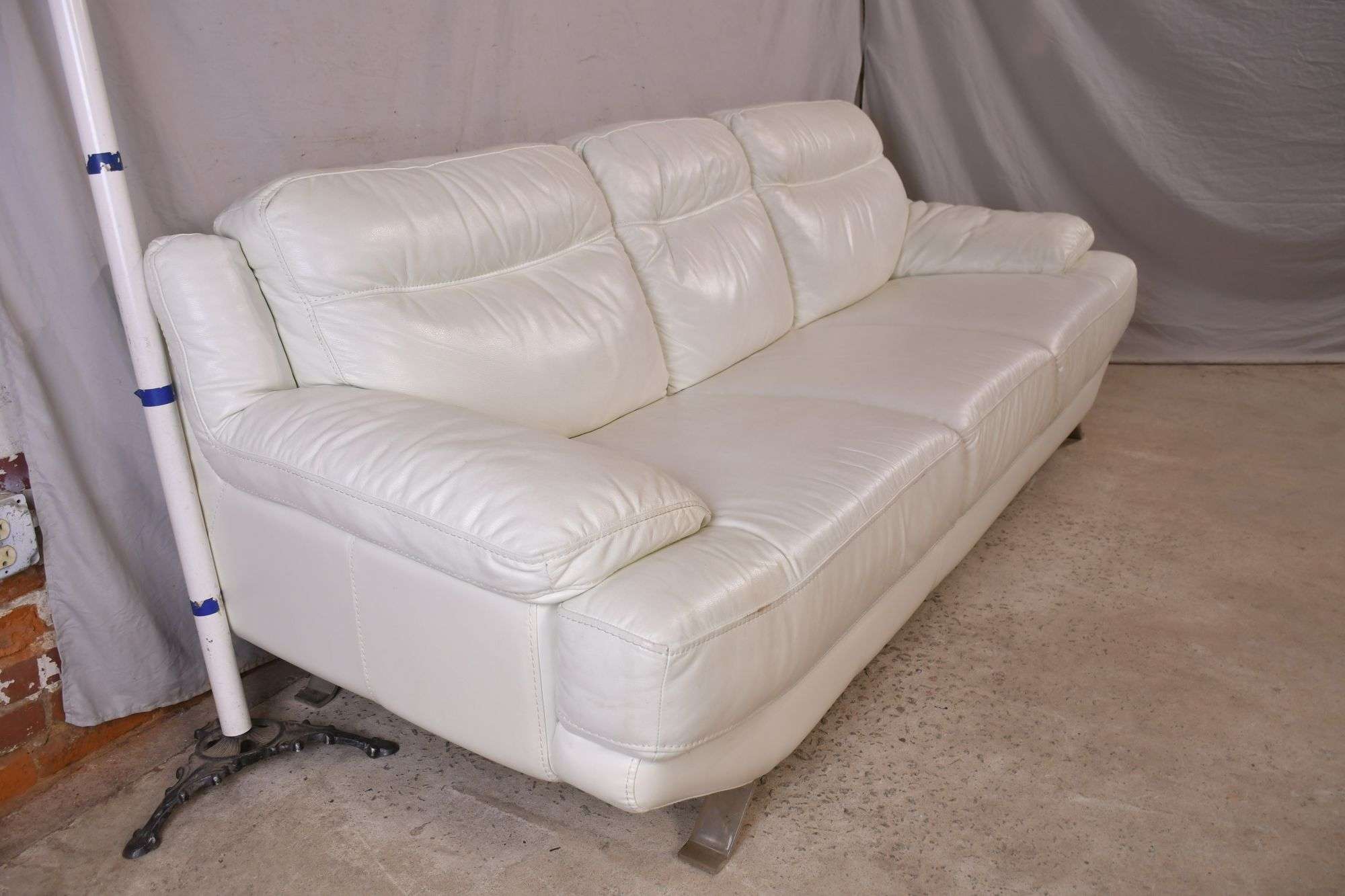 Sofia Vergara white leather sofa with polished metal legs; 336
