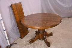 Round oak single pedestal dining table with 1 skirted leaf; 3453-045
