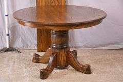 Round oak single pedestal dining table with 1 skirted leaf; 3453-045