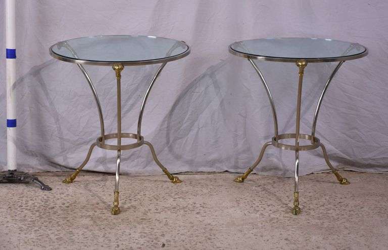 Pair of round silver metal glass top side tables with brass rams heads and hoof feet; 68-7829