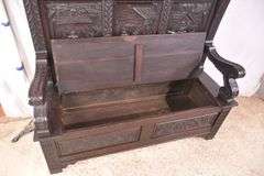 Carved oak bench with lift-top storage seat; 68-6821