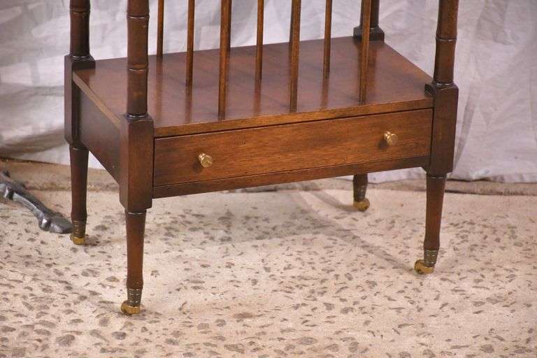 Mahogany single drawer canterbury with brass toe caps and casters; 396-1389