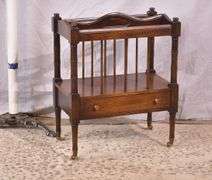 Mahogany single drawer canterbury with brass toe caps and casters; 396-1389