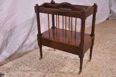 Mahogany single drawer canterbury with brass toe caps and casters; 396-1389