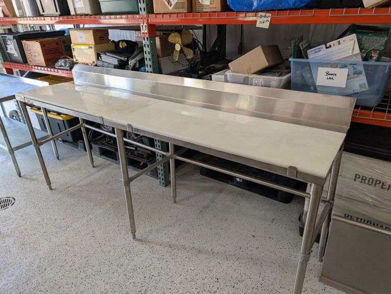 Regency stainless table with plastic cutting board tops.