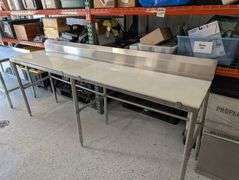 Regency stainless table with plastic cutting board tops.