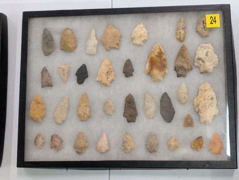 Collection of 34 arrowhead points in 12x16 riker display