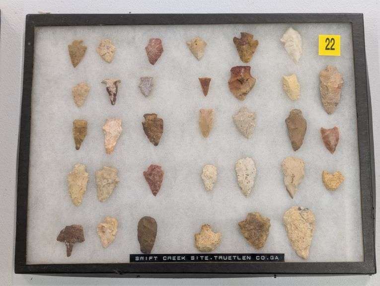 Collection of 33 arrowhead points in 12x16 riker display
