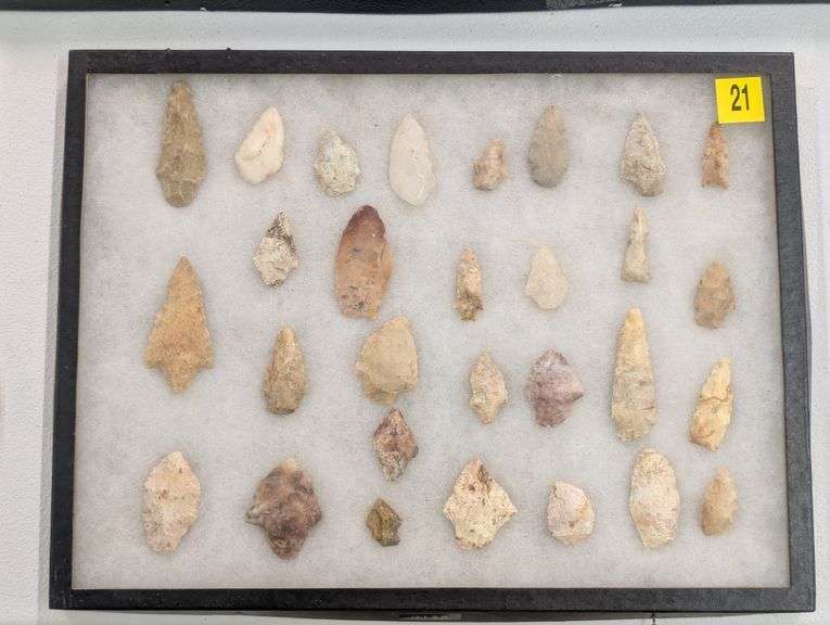 Collection of 29 arrowhead points in 12x16 riker display