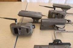 10 Cuddeback game cameras w/poles & accessories