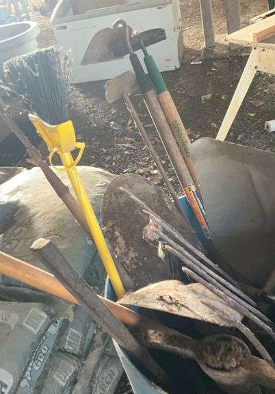 Plastic barrel containing handle tools-hoes,shovels, rakes,brooms, pry bar