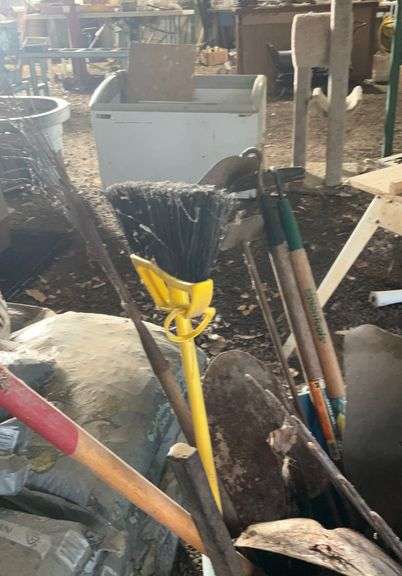 Plastic barrel containing handle tools-hoes,shovels, rakes,brooms, pry bar