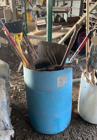 Plastic barrel containing handle tools-hoes,shovels, rakes,brooms, pry bar