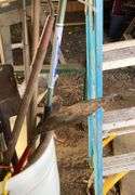 Plastic barrel containing handled tools-shovels, potato fork, rake, pruning shears, pry bar