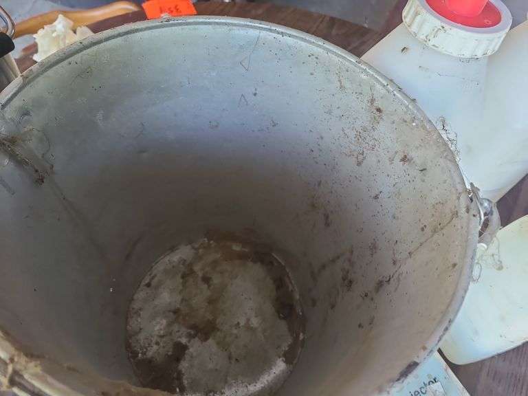 Galvanized Bucket containing calf bottles, Ralgro 