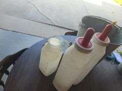 Galvanized Bucket containing calf bottles, Ralgro 