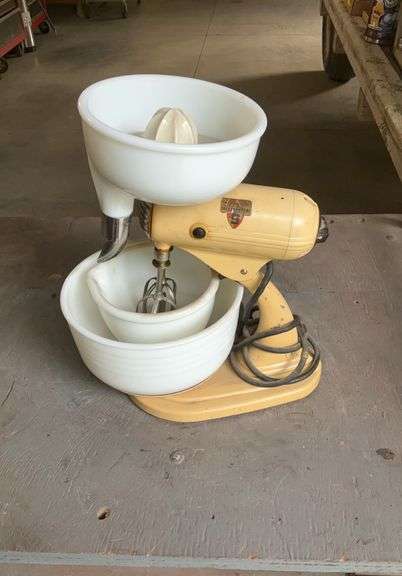 Vintage Sunbeam mixmaster with juicer, two bowls, and beaters