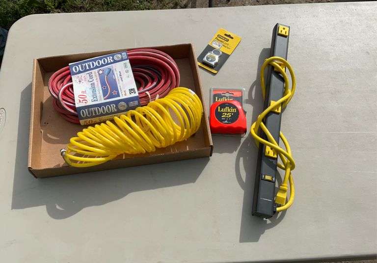 Flat with extension cords, power strips, air hose, tape measures