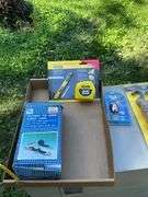 flat of tie down straps, tape measure & blade & LED keychain light