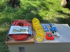 Flat with extension cords, power strip, tape measures, air hose