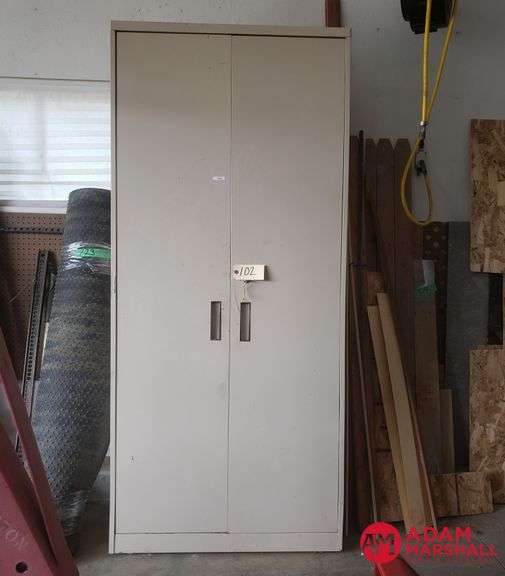 Upright metal cabinet with adjustable shelving. Locking doors with key.