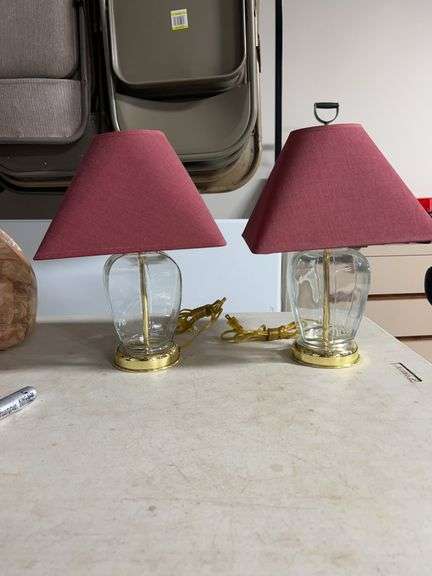 pair of glass and polished brass table lamps with square maroon/red shades.